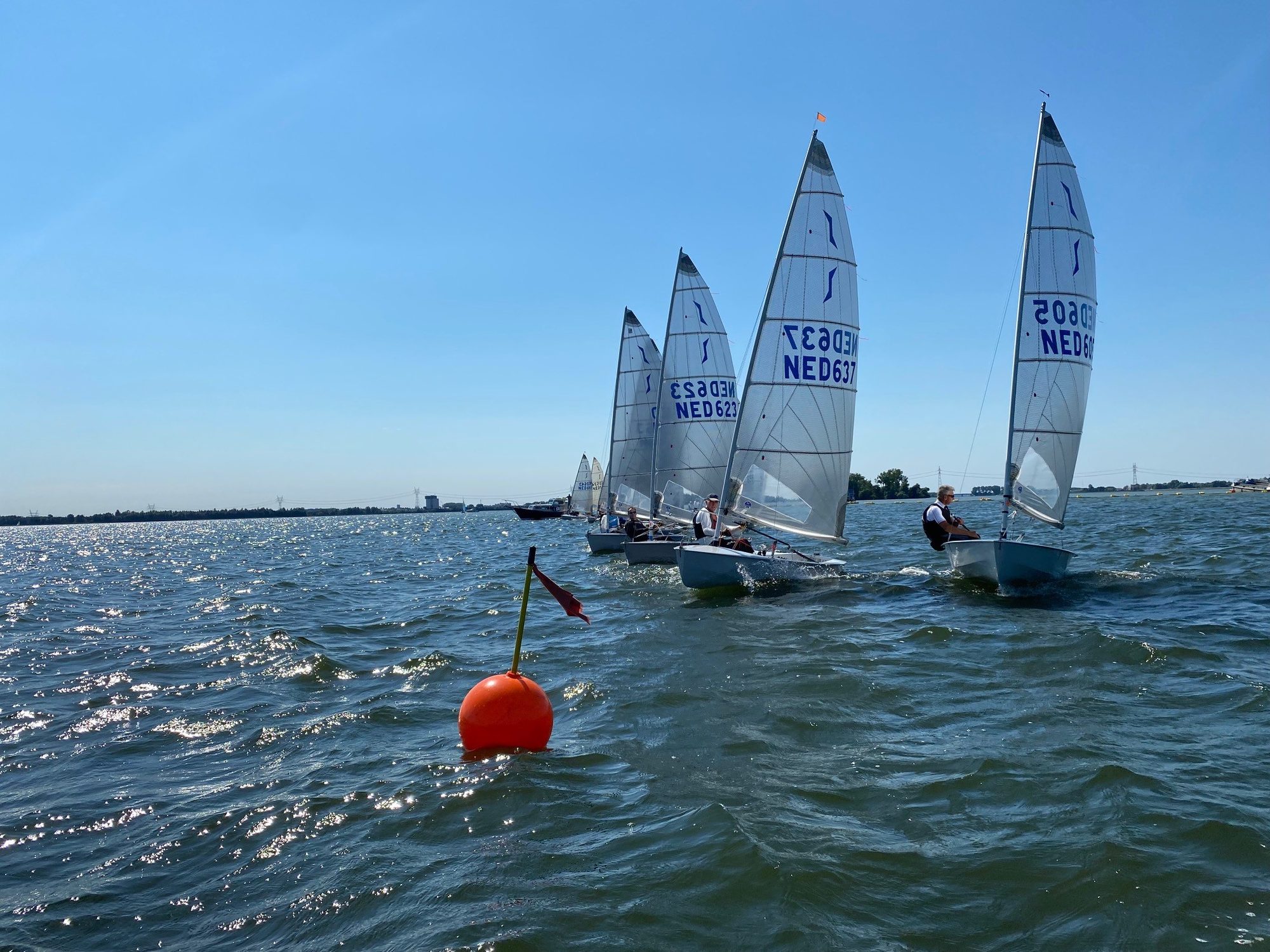 Solo-zeilers ronden een boei op het zonnige Veluwemeer