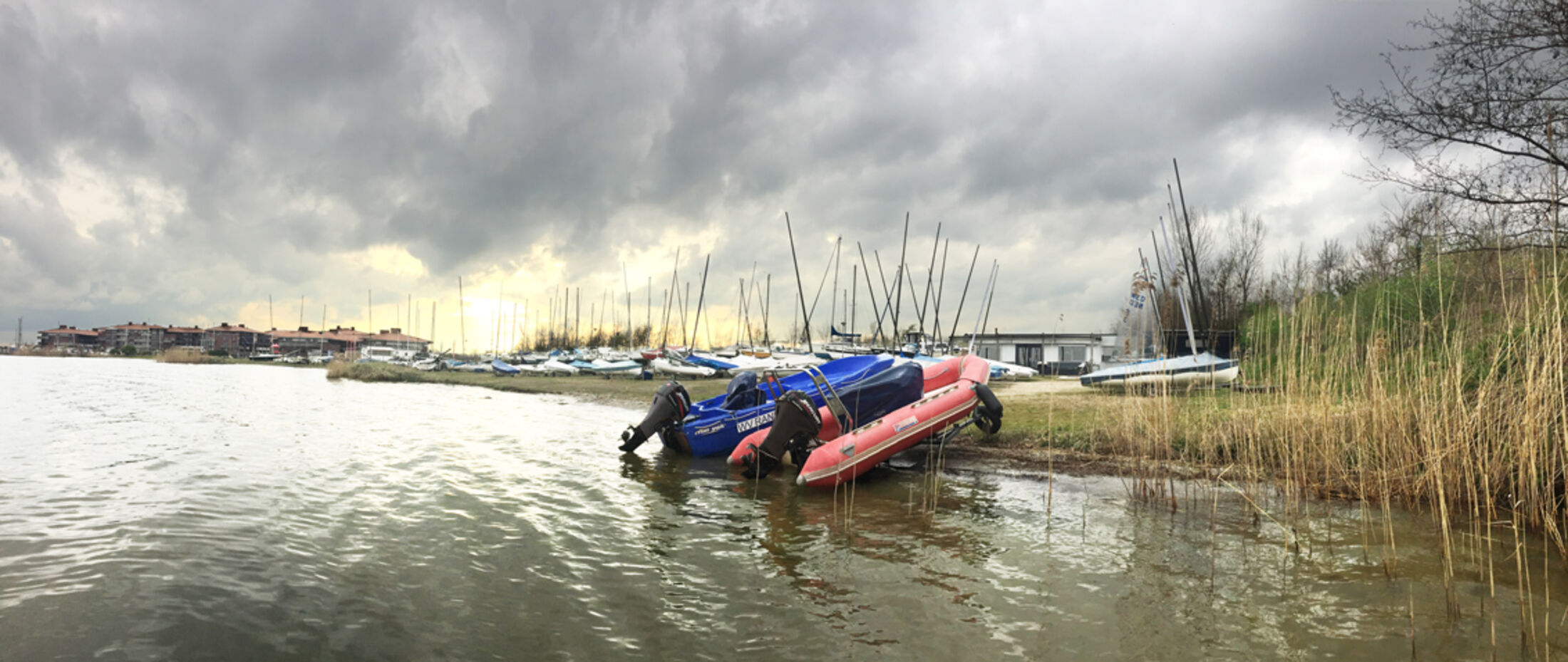 Catamarans aan de wal onder een dramatische wolkenlucht