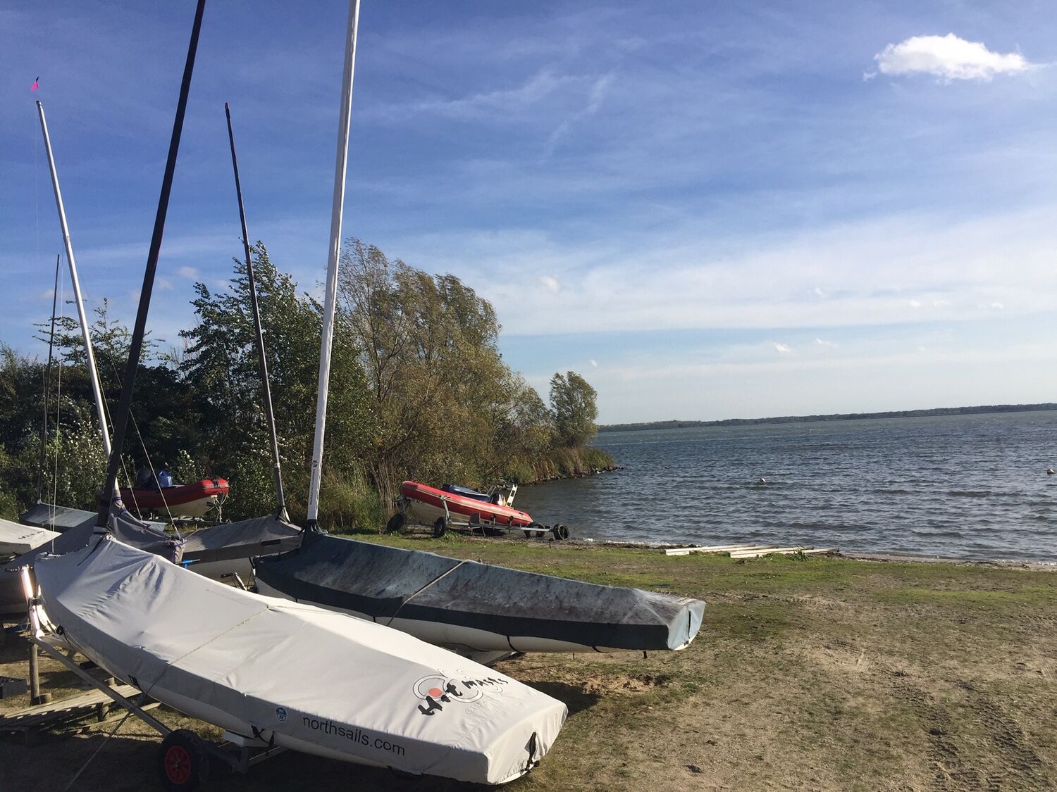 Boten aan de walkant met uitzicht over het meer